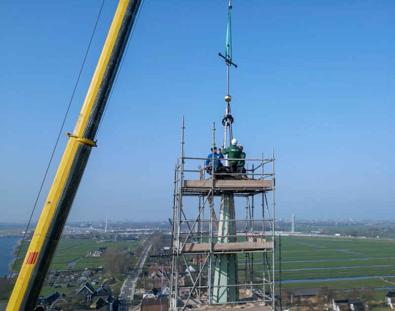 Plaatsen van het kruis op de toren